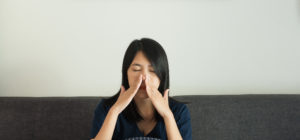 Woman suffering from sinus issues that could be treated by chiropractic care